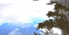 雨上がりの水たまりに広がる空と雲の幻想的な映り込み風景