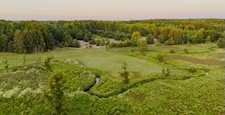 Aerial Sunset Over Lush Green Fields and Forest