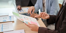 A professional businesswoman reading and reviewing documents in the meeting.